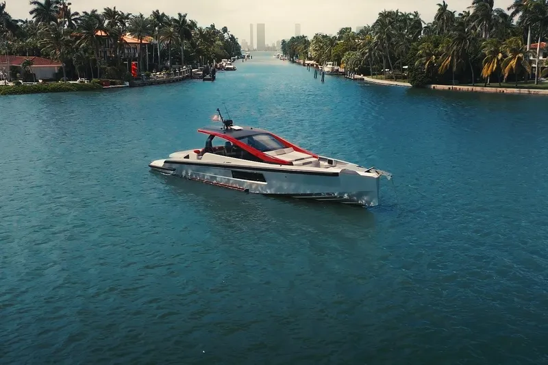 Slide: The Image of Futuristic Maori 54XL yacht cruising through a scenic, palm-lined waterway. - 10