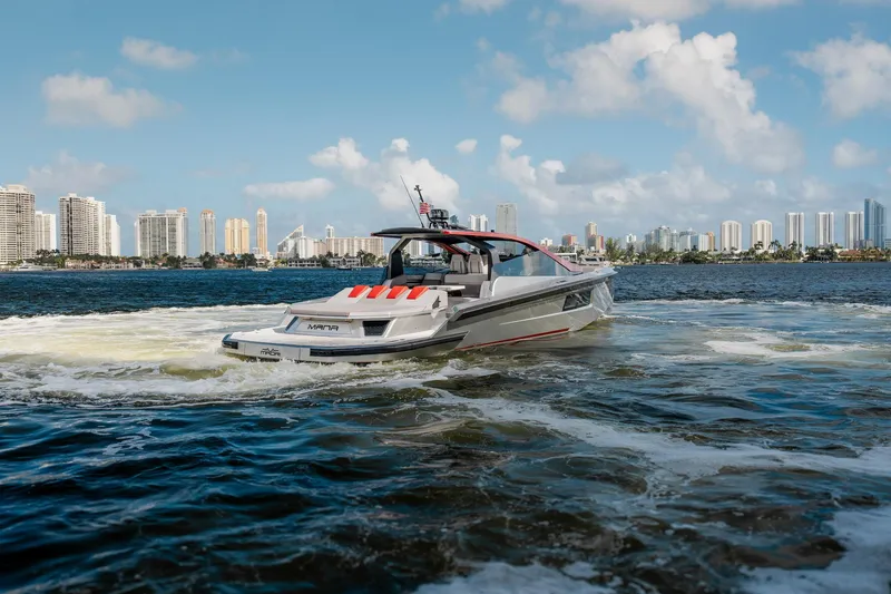 Slide: The Image of Luxury Maori 54XL yacht cruising near city skyline, 2025 model. - 2