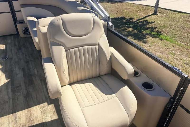 Slide: The Image of 2016 Crest II 230 SLC boat interior with beige seating and cup holders. - 10