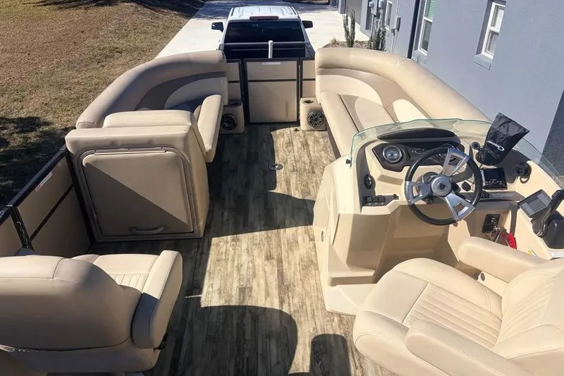 Slide: The Image of 2016 Crest II 230 SLC pontoon boat interior with beige seating and modern dashboard. - 16