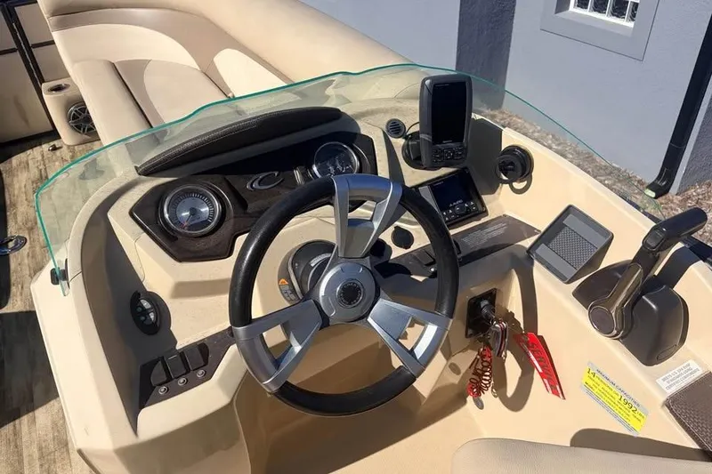 Slide: The Image of 2016 Crest II 230 SLC boat dashboard with steering wheel and control panel. - 24