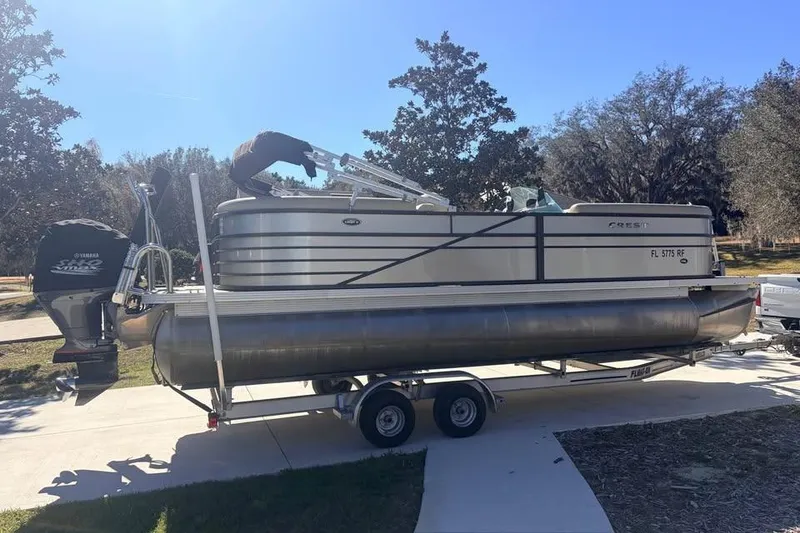 Slide: The Image of 2016 Crest II 230 SLC pontoon boat on trailer, parked outdoors. - 3