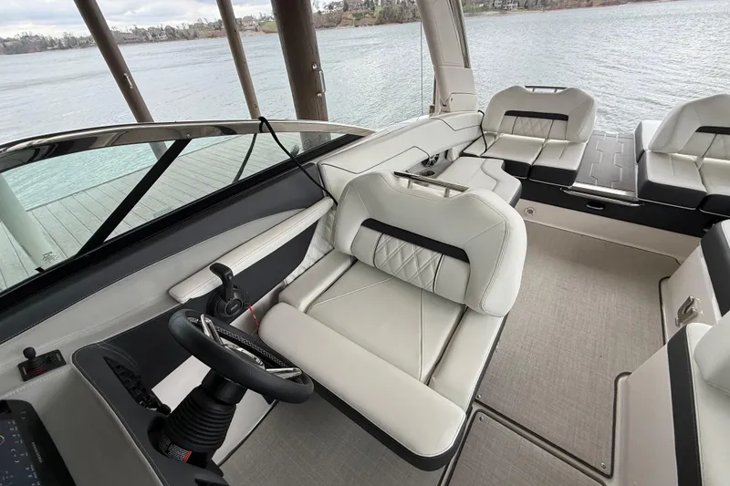 Slide: The Image of 2024 Regal LS4 boat interior with luxurious seating and steering wheel, dockside view. - 11