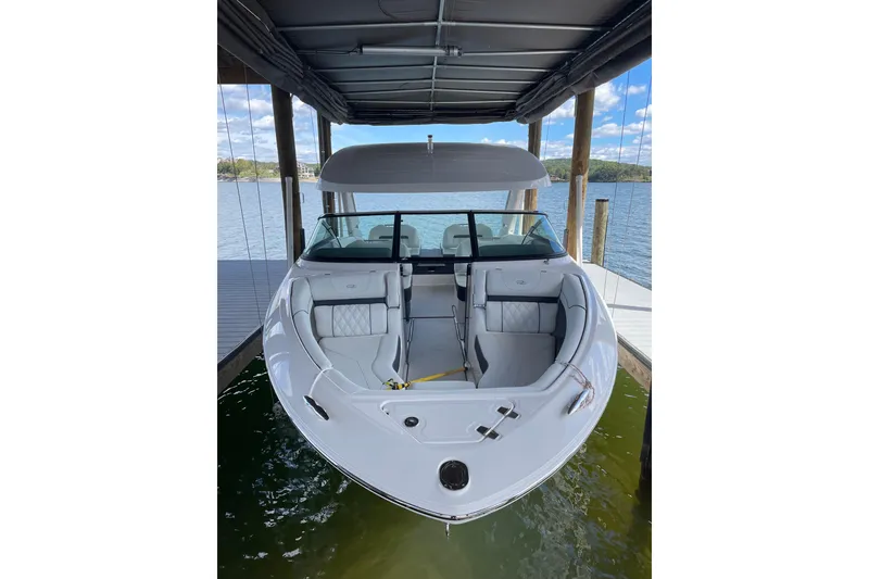 Slide: The Image of 2024 Regal LS4 boat covered and docked by a lakeside pier. - 3