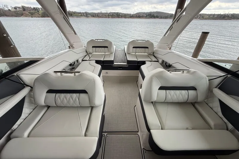 Slide: The Image of 2024 Regal LS4 boat interior with luxurious seating on a calm lake. - 4