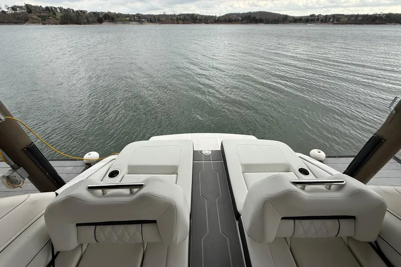 Slide: The Image of 2024 Regal LS4 boat with luxurious seating overlooking a serene lake. - 9