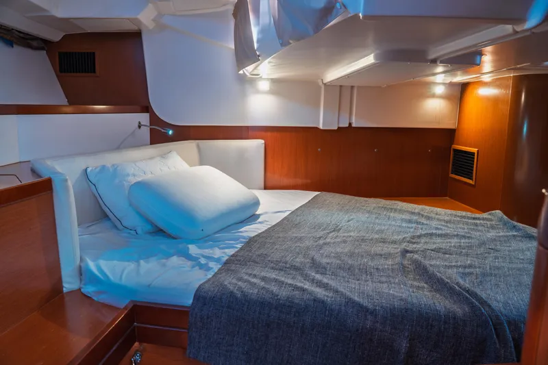 Slide: The Image of Cozy cabin interior of 2011 Beneteau Oceanis 50 sailboat with bed and ambient lighting. - 31
