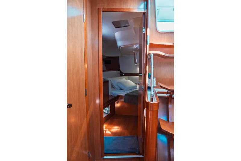 Slide: The Image of Interior cabin of 2011 Beneteau Oceanis 50 yacht, featuring wooden finishes and cozy bedding. - 32