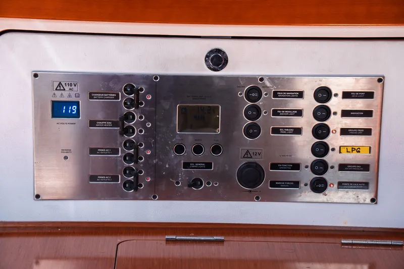 Slide: The Image of Control panel of a 2011 Beneteau Oceanis 50 yacht, featuring various switches and voltage display. - 37