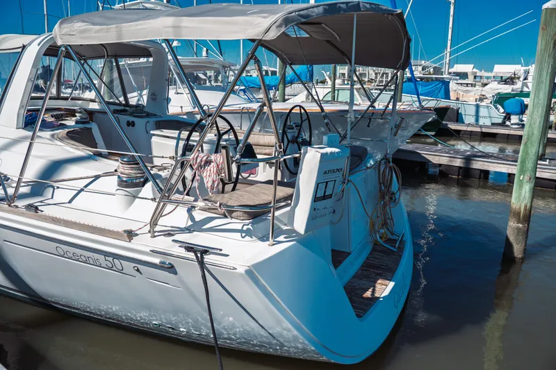 Slide: The Image of 2011 Beneteau Oceanis 50 sailboat docked at marina, featuring dual steering wheels. - 6