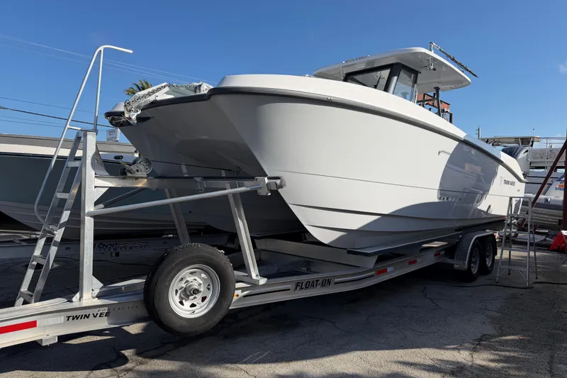 Slide: The Image of 2026 Twin Vee 280 GFX2 CC boat on display under a clear blue sky. - 2