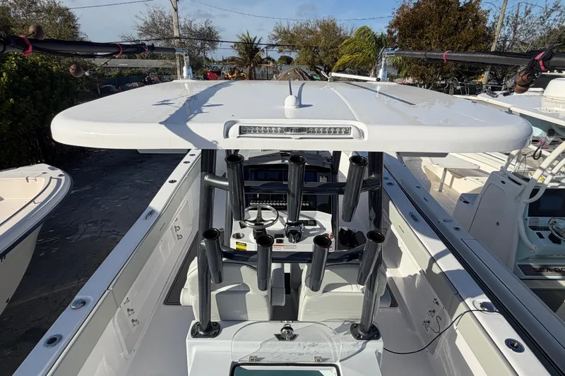 Slide: The Image of 2026 Twin Vee 280 GFX2 CC boat with rod holders and T-top in marina. - 4