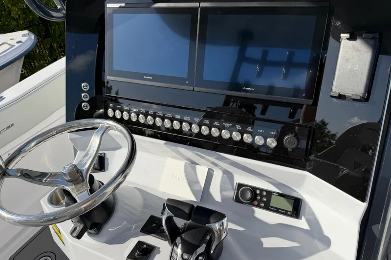 Slide: The Image of 2026 Twin Vee 280 GFX2 CC boat dashboard with dual Garmin screens and steering wheel. - 7