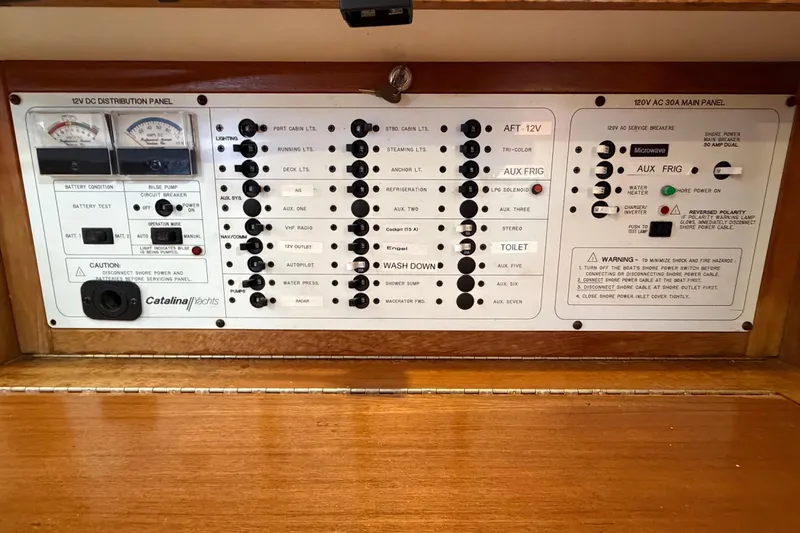 Slide: The Image of Electrical control panel of a 1998 Catalina 380 yacht, featuring various switches and gauges. - 17