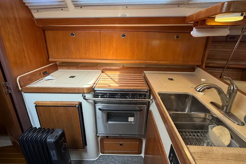 Slide: The Image of Galley kitchen in 1998 Catalina 380 sailboat with wood cabinetry and stainless steel sink. - 20