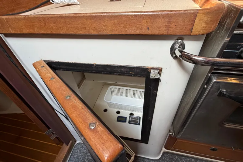Slide: The Image of Open storage compartment in 1998 Catalina 380 sailboat galley with wooden trim. - 24