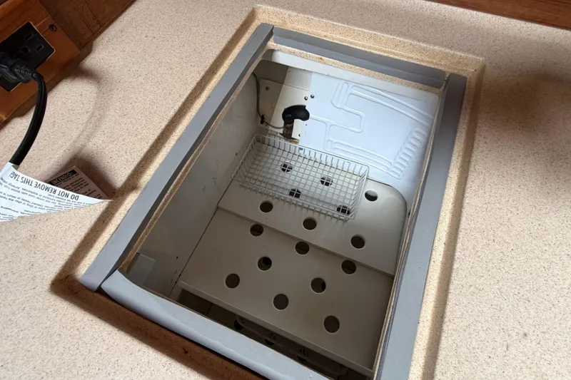 Slide: The Image of Built-in cooler compartment on a 1998 Catalina 380 sailboat, featuring a perforated shelf. - 25