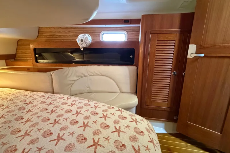 Slide: The Image of Cozy cabin interior of 1998 Catalina 380 sailboat with wood paneling and nautical bedding. - 31
