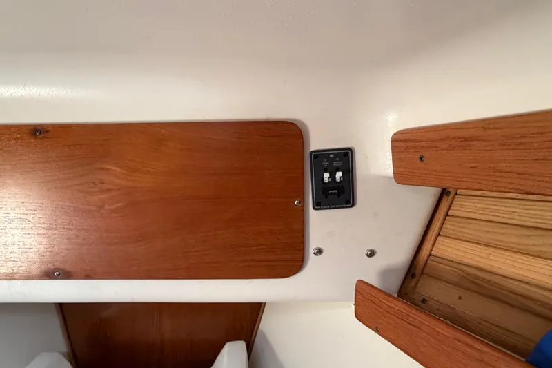 Slide: The Image of Interior of a 1998 Catalina 380 sailboat featuring wooden panels and a control switch. - 42
