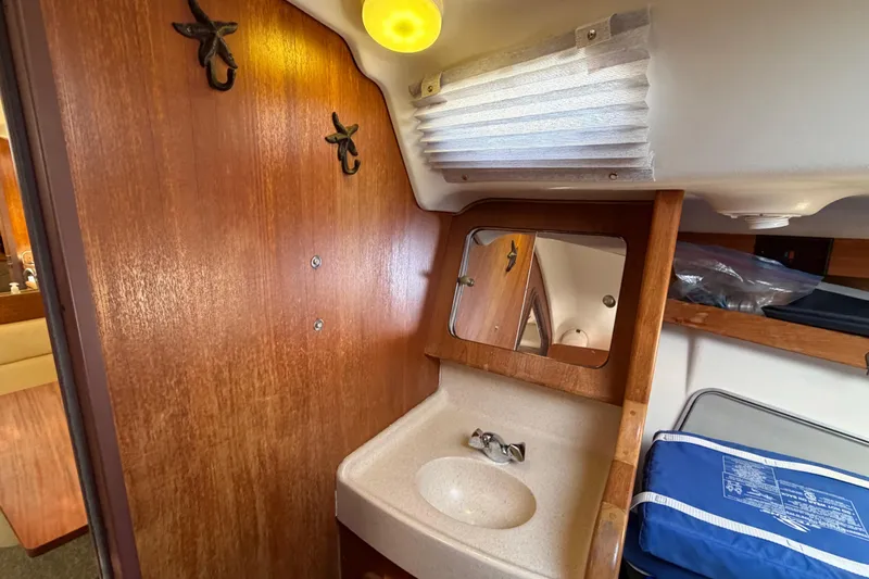 Slide: The Image of Interior of 1998 Catalina 380 sailboat with wooden cabinetry and compact sink area. - 43