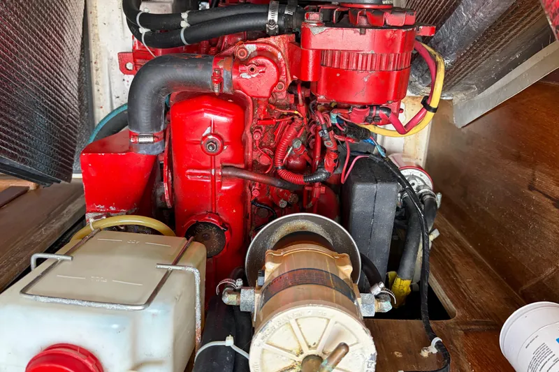 Slide: The Image of Engine compartment of a 1998 Catalina 380 sailboat, featuring a red engine and various components. - 44