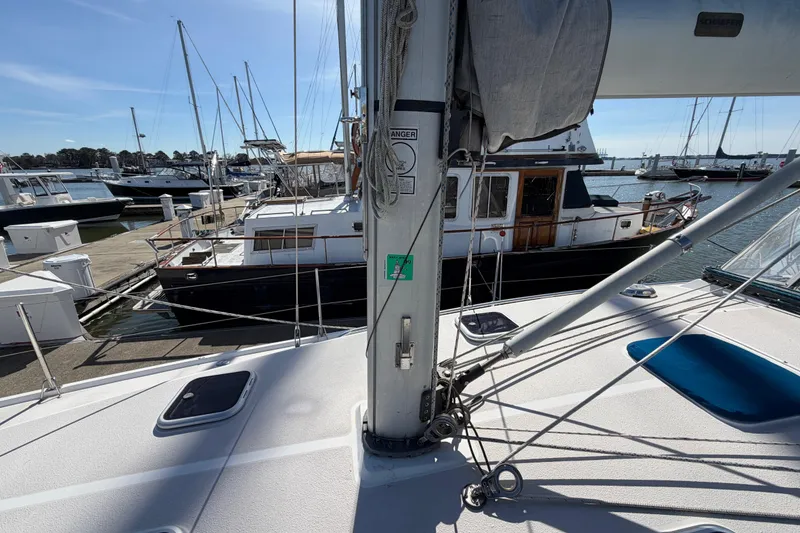 Slide: The Image of 1998 Catalina 380 sailboat docked at marina, surrounded by other boats under clear blue sky. - 53