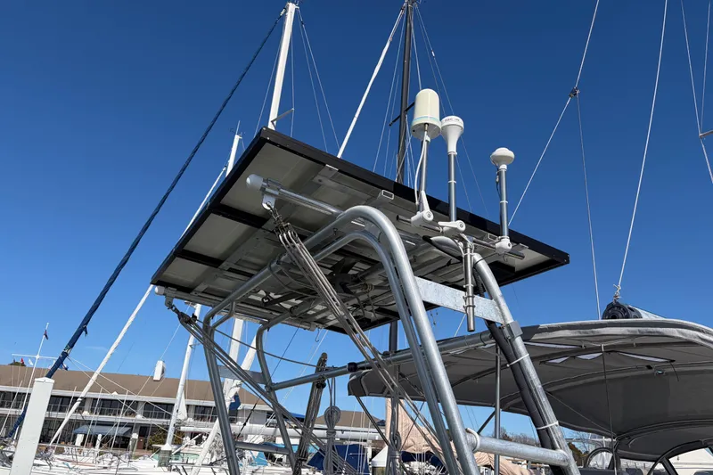 Slide: The Image of Sailboat Catalina 380 (1998) with solar panels and antennas, docked under clear blue sky. - 65
