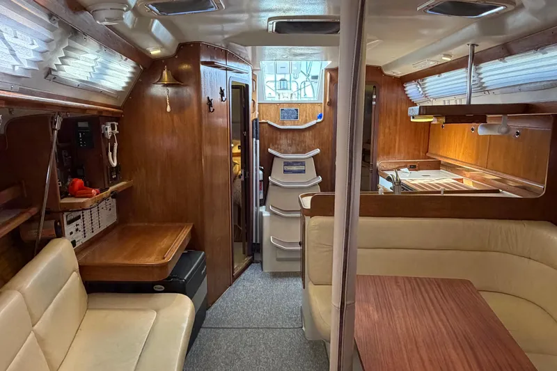 Slide: The Image of Interior of a 1998 Catalina 380 sailboat with wood finishes and cozy seating. - 7