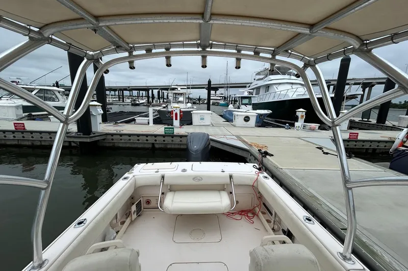 Slide: The Image of 2011 Grady-White Freedom 225 boat docked at a marina with other vessels. - 16