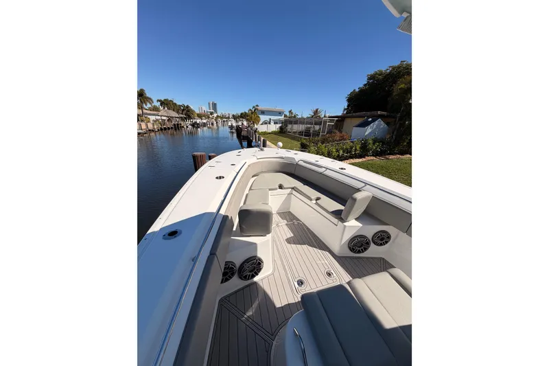 Slide: The Image of 2023 Cape Horn 32 XS boat interior with seating and speakers, docked by a canal. - 15