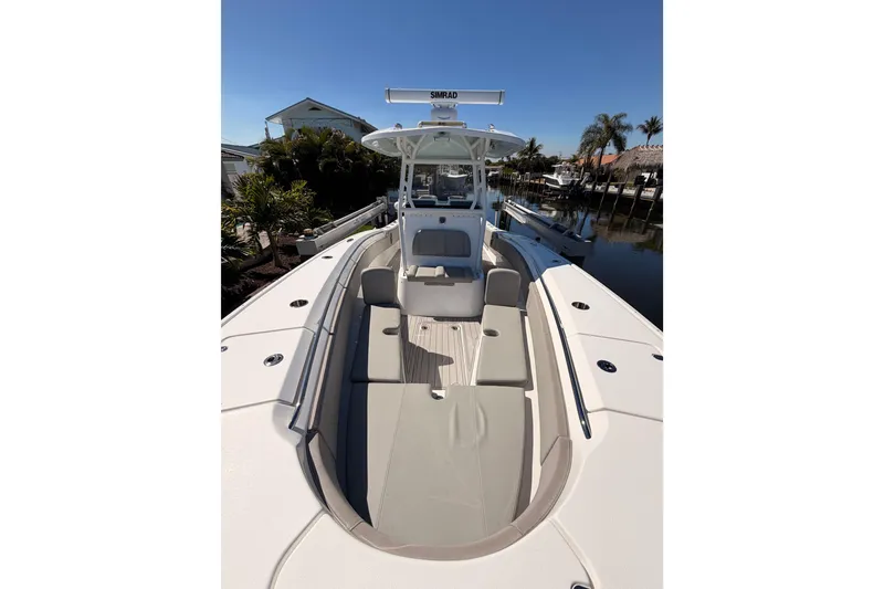 Slide: The Image of 2023 Cape Horn 32 XS boat with spacious deck and seating, docked near palm trees. - 16