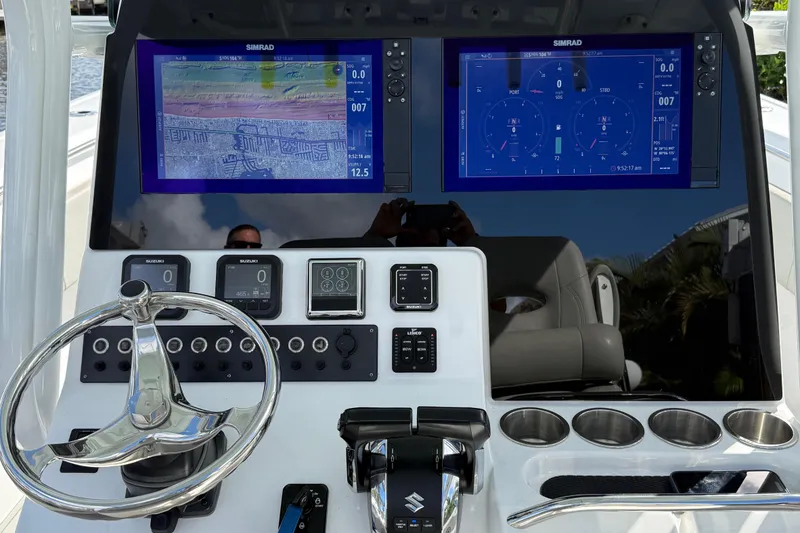 Slide: The Image of 2023 Cape Horn 32 XS boat dashboard with dual Simrad displays and steering wheel. - 20