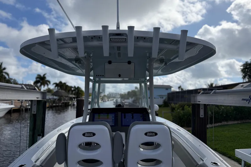 Slide: The Image of 2023 Cape Horn 32 XS boat interior with helm and seating, docked by a canal. - 23