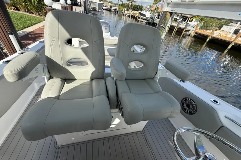 Slide: The Image of 2023 Cape Horn 32 XS boat interior with dual gray captain's chairs by the water. - 24