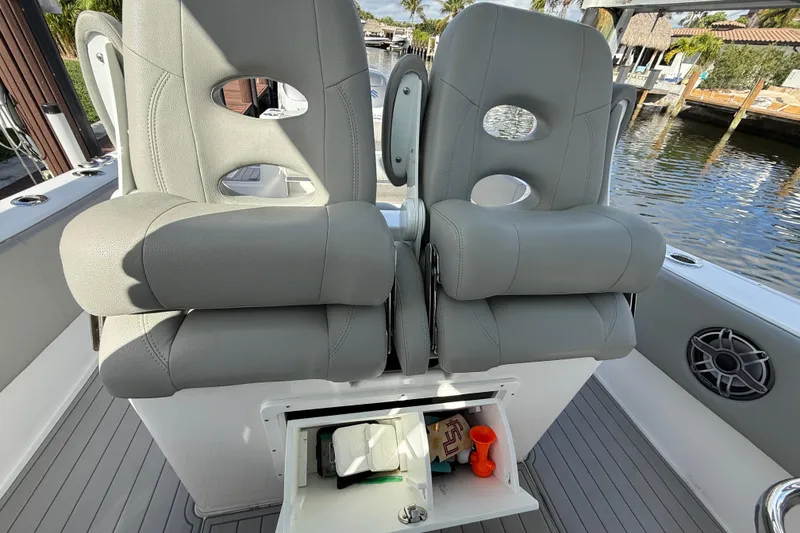 Slide: The Image of 2023 Cape Horn 32 XS boat seats with storage compartment open, dockside view. - 25