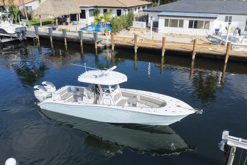 Slide: The Image of 2023 Cape Horn 32 XS boat cruising in a calm marina with waterfront homes. - 4