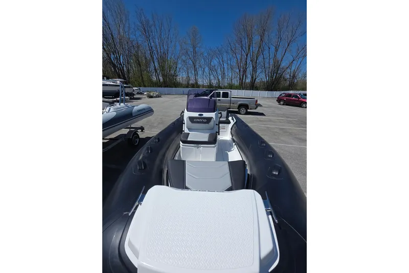 Slide: The Image of 2026 Grand Inflatables G420 boat in parking lot, showcasing sleek design and seating. - 9