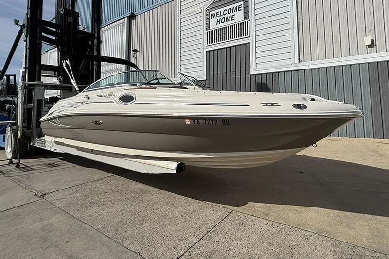 Slide: The Image of 2005 Sea Ray 240 Sundeck boat on a forklift near a building. - 1