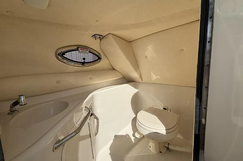 Slide: The Image of Interior of 2005 Sea Ray 240 Sundeck boat bathroom with toilet and sink. - 16