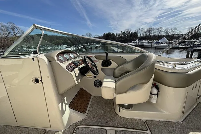 Slide: The Image of 2005 Sea Ray 240 Sundeck boat interior with steering wheel and seating at marina. - 17