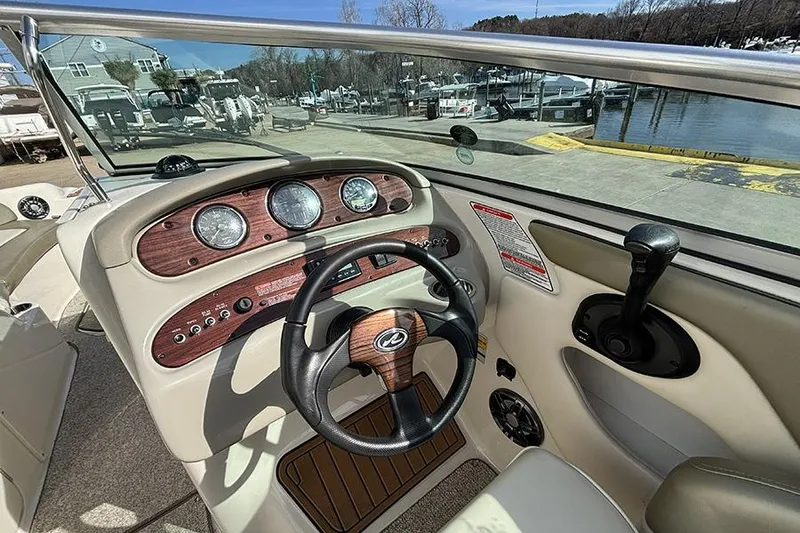 Slide: The Image of 2005 Sea Ray 240 Sundeck dashboard with steering wheel and control panel. - 19