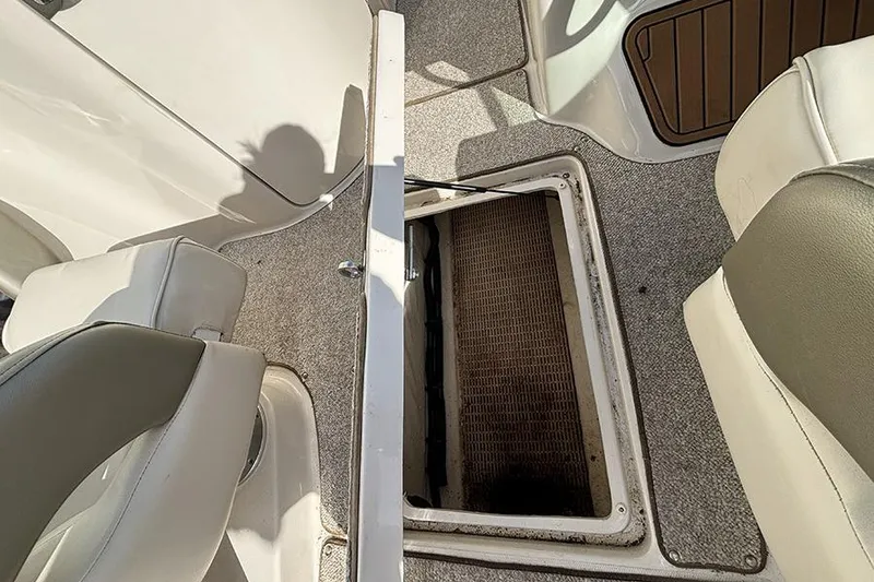 Slide: The Image of 2005 Sea Ray 240 Sundeck interior with open storage compartment and seating. - 20