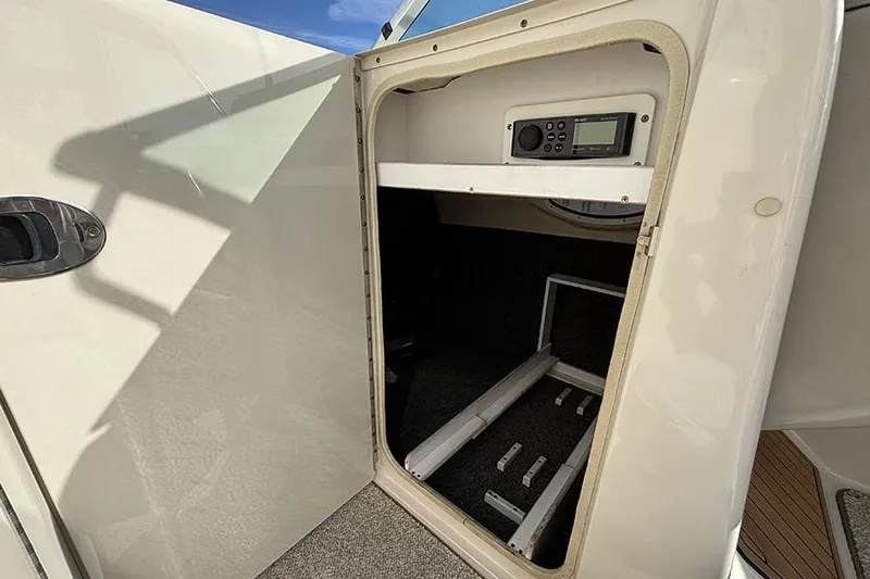 Slide: The Image of Open storage compartment on 2005 Sea Ray 240 Sundeck boat with control panel. - 21
