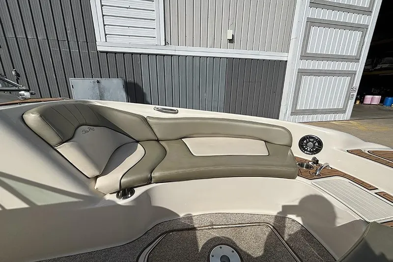 Slide: The Image of Interior seating of a 2005 Sea Ray 240 Sundeck boat, featuring beige upholstery. - 24
