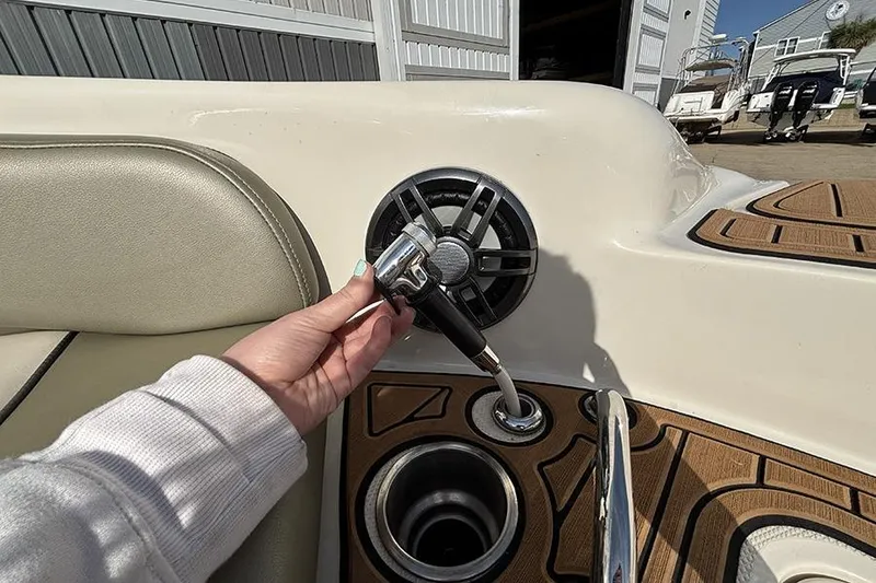 Slide: The Image of Hand holding a showerhead on a 2005 Sea Ray 240 Sundeck boat deck. - 27
