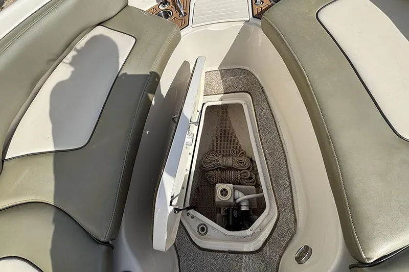 Slide: The Image of 2005 Sea Ray 240 Sundeck interior storage compartment with open hatch and rope. - 28