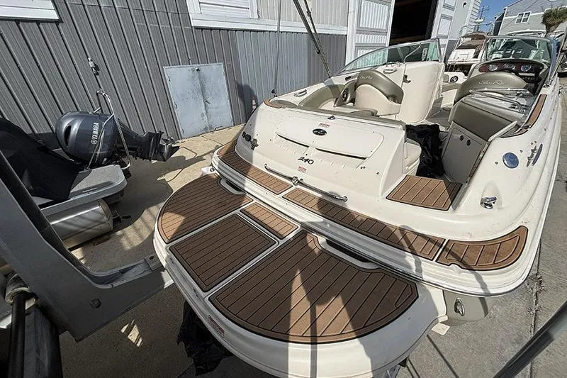 Slide: The Image of 2005 Sea Ray 240 Sundeck boat with wooden deck, docked near a Yamaha engine. - 29