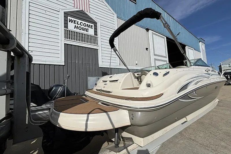 Slide: The Image of 2005 Sea Ray 240 Sundeck boat docked near a welcoming boathouse. - 3