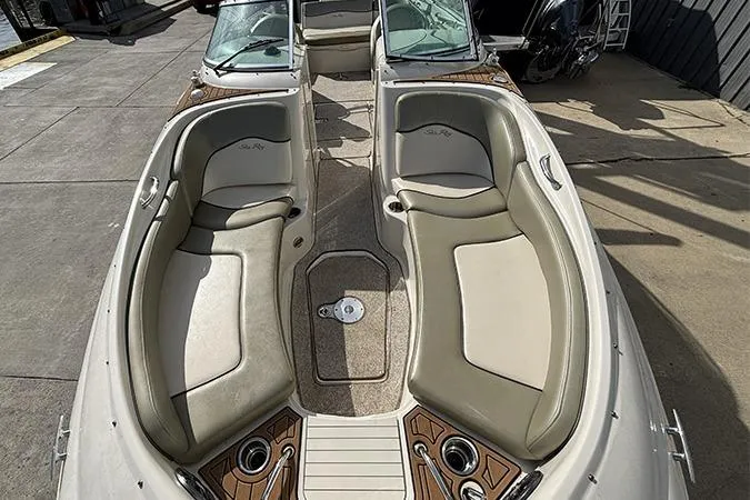 Slide: The Image of 2005 Sea Ray 240 Sundeck boat interior with beige seating and wood accents. - 30