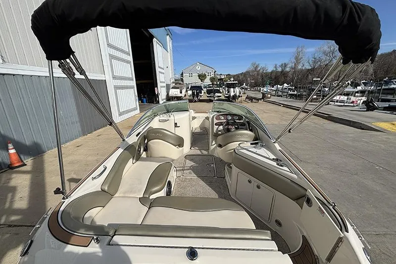 Slide: The Image of 2005 Sea Ray 240 Sundeck boat interior with seating and steering wheel, docked at marina. - 4